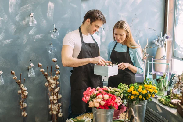 Dos asistentes de tienda quieren enviar flores a los compradores — Foto de Stock