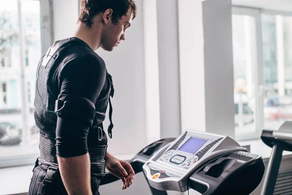 Ems eğitim salonunda treadmill çalışan siyah elbiseli adam