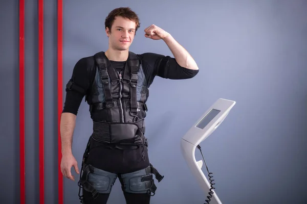 Homme près de la machine EMS, stimulation musculaire, montrant des biceps — Photo