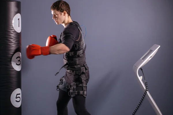 Man in bokshandschoenen tijdens de training. bokser in pak van elektrische stimulatie — Stockfoto