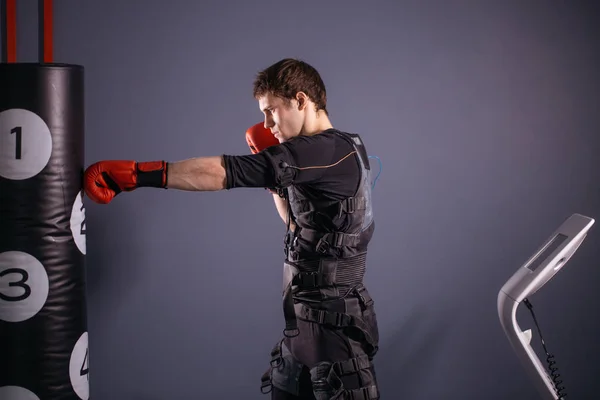 Hombre con guantes de boxeo durante el entrenamiento. boxeador en traje de estimulación eléctrica —  Fotos de Stock