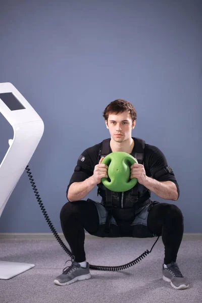 Hombre en traje muscular eléctrico para estimular con el entrenamiento medecine ball —  Fotos de Stock