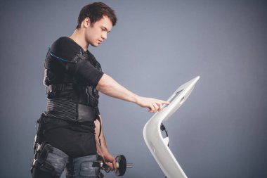 dambıl ile ayakta elektrik kas stimülasyonu elbiseli adam