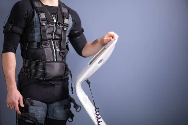 Athlete regulating intensity of ems electro muscular stimulation machine — Stock Photo, Image