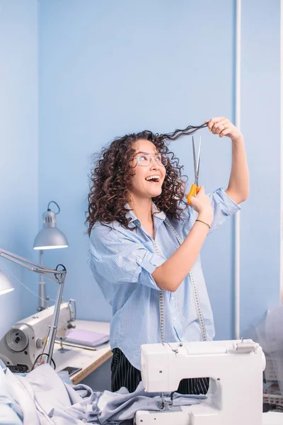 Naaister snijden haar krullen met kleermakers schaar oneven curlshappiness van verandering — Stockfoto