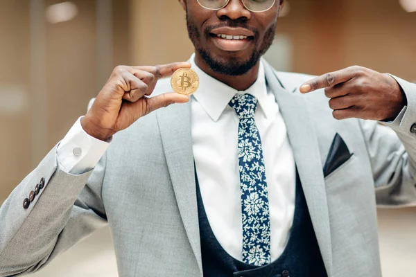 Bitcoin dourado em uma mão de homem, símbolo Digitall de uma nova moeda virtual — Fotografia de Stock