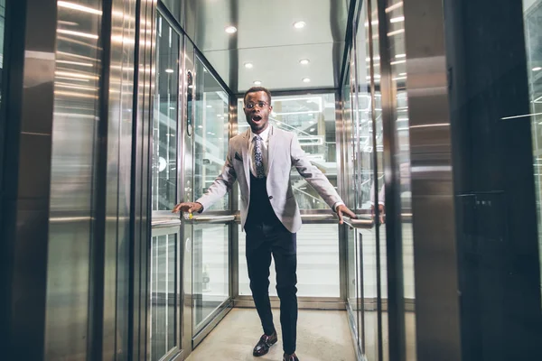 エレベーターの中悲鳴しているアフリカの実業家。恐怖閉所恐怖症の概念 — ストック写真