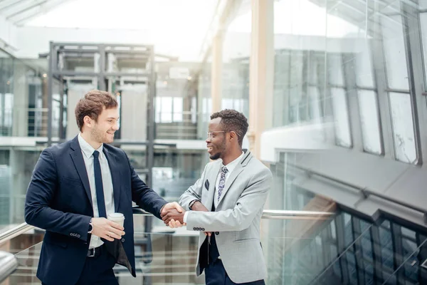 Dos hombres de negocios multirraciales apretón de manos en la oficina moderna para el final de mucho — Foto de Stock