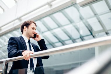 Çalışmak için yolda cep telefonunda konuşurken yürüyüş iş adamı