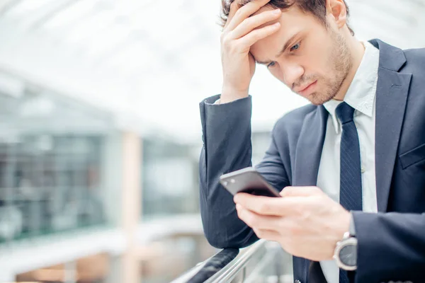 Jovem empresário preocupado Leia texto no celular — Fotografia de Stock