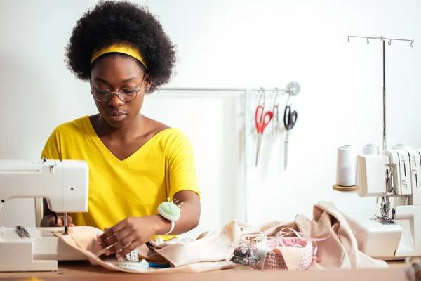 Donna cucitrice seduta e cuce sulla macchina da cucire. Dressmaker al lavoro — Foto Stock