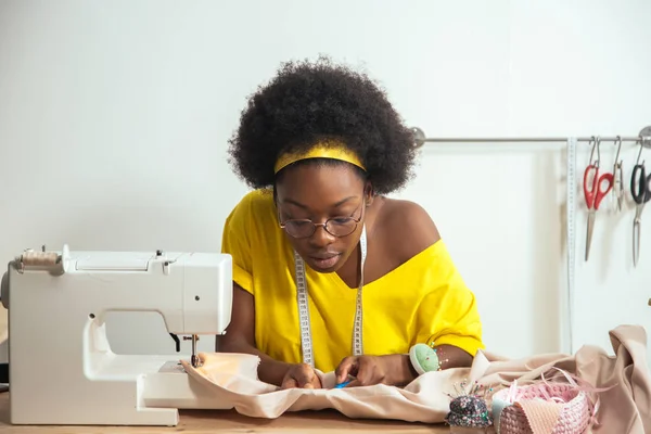 sewing fabric with needle at seamstress workplace