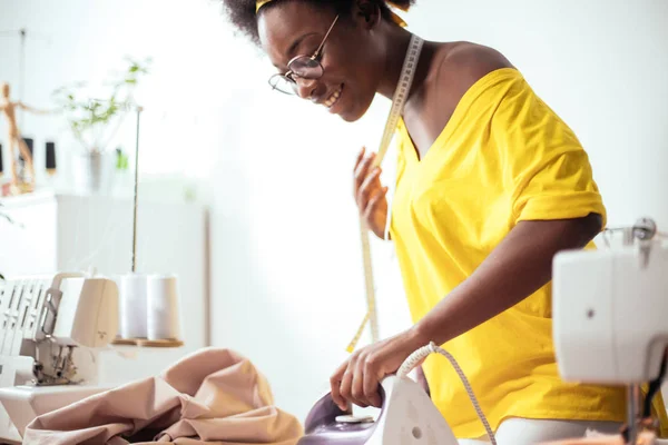 Afrikaanse vrouw naaister strijkdoek — Stockfoto