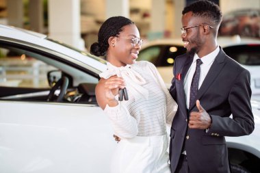 Araba Bayilik ziyaret etti. Çift holding anahtar kameraya bakarak onların yeni araba