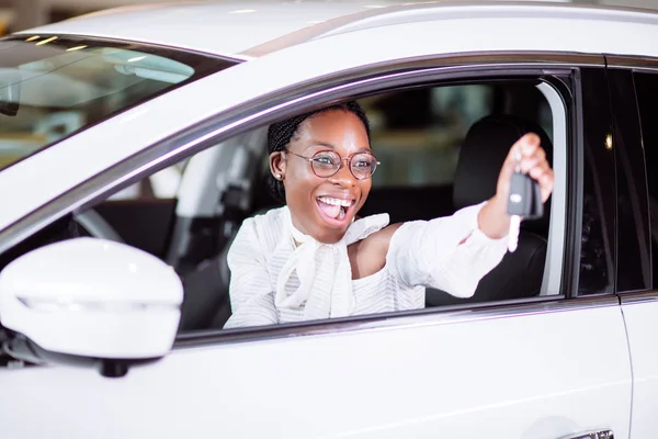 Mulher africana com seu novo carro mostrando chave — Fotografia de Stock