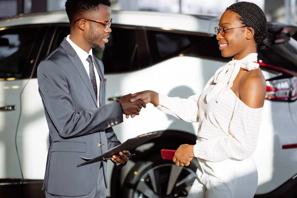 顾客在汽车经销处买车。女人和男人握手 — 图库照片