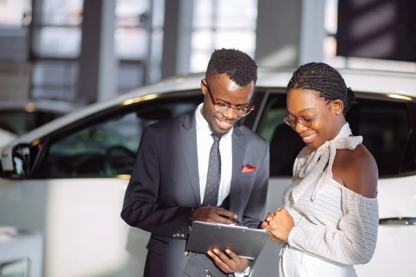 Autohändler zeigt schwarzer Frau Fahrzeug — Stockfoto