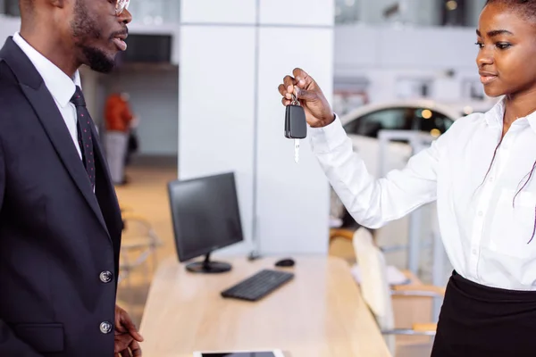 销售情况在汽车经销商, 年轻的非洲夫妇获得新车的关键 — 图库照片