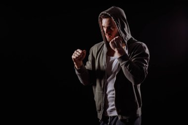 yan görünümü atış ciddi genç erkek sıkışık yumruk ile kapatın. Korkusuz adam