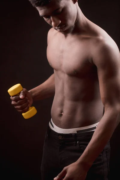 Simpatico atleta afro mantenendo un piccolo manubrio e controllando la muscolatura . — Foto Stock