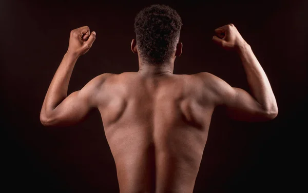 Bakifrån bild av Afro amerikansk starka manliga böja armbågarna biceps — Stockfoto