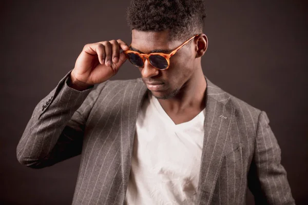 Hombre africano guapo en gafas de sol con estilo, chaqueta de traje y camiseta blanca — Foto de Stock