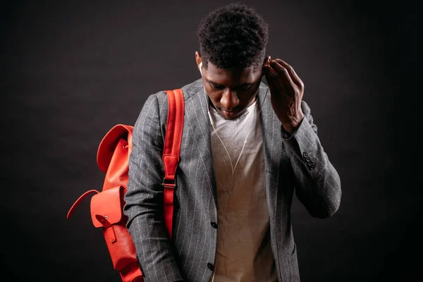 Retrato de jovem e bonito homem africano com mochila e fones de ouvido — Fotografia de Stock