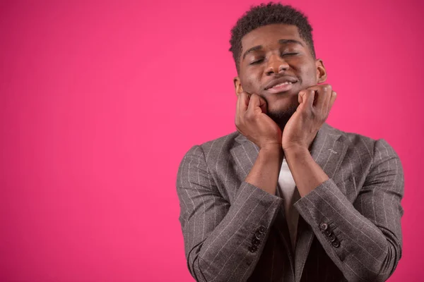 Jonge zwarte man met gesloten ogen raakt zijn kin met handen — Stockfoto