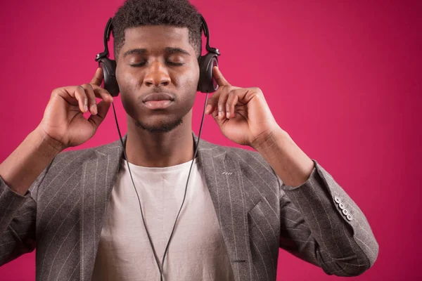 Afro facet z zamkniętymi oczami, słuchanie muzyki na słuchawkach. skoncentrować się na muzyce — Zdjęcie stockowe