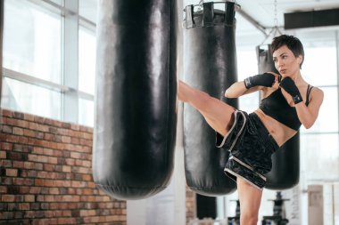 kick boks spor elbise ve bandaj bacakları ve kolları ile yumruk atıyor