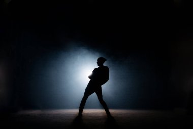 genç erkek karanlık sahnede dans. ilk performans. bükülmüş vücut