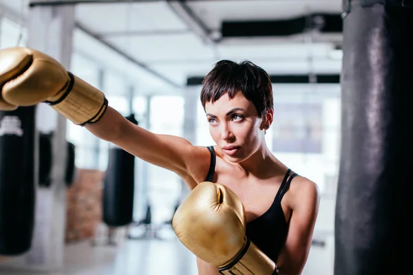 Vista lateral tiro de mulher corajosa em pé na pose de boxe — Fotografia de Stock