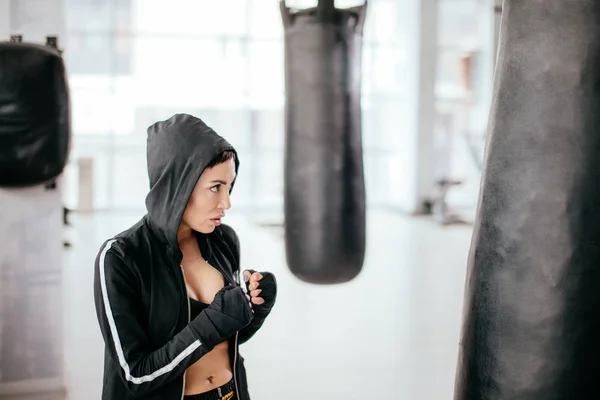 Femme avec les poings serrés à la salle de gym avec des installations sportives — Photo