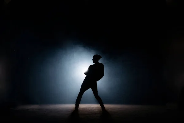 年轻男子在黑暗舞台上跳舞。第一次演出。身体弯曲 — 图库照片