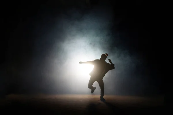 Pose de baile de hombre en una pierna sobre el fondo oscuro —  Fotos de Stock