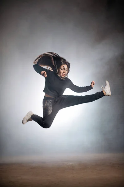 Jonge Sportvrouw is springen buigen van een been buiten — Stockfoto