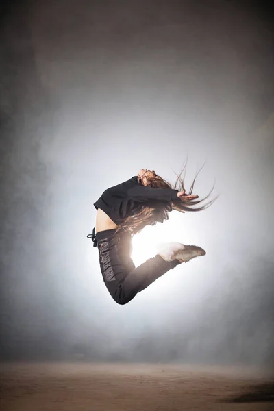 Νεαρή γυναίκα με μακριά μαλλιά εκτελεί δροσερό stunt ευελιξία του σώματος. — Φωτογραφία Αρχείου