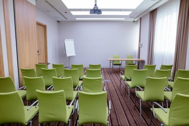 large new meeting room with rows of modern green chairs clipart