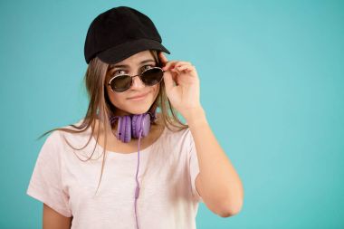 genç kadın, güneş gözlüğü ve kulaklık Siyah şapkası