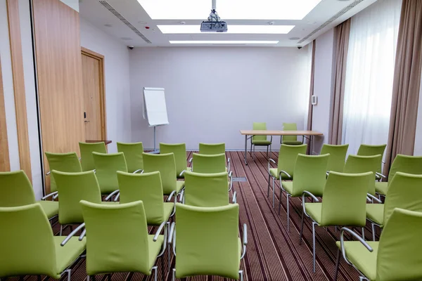 Велика нова кімната для переговорів з рядами сучасних зелених стільців — стокове фото