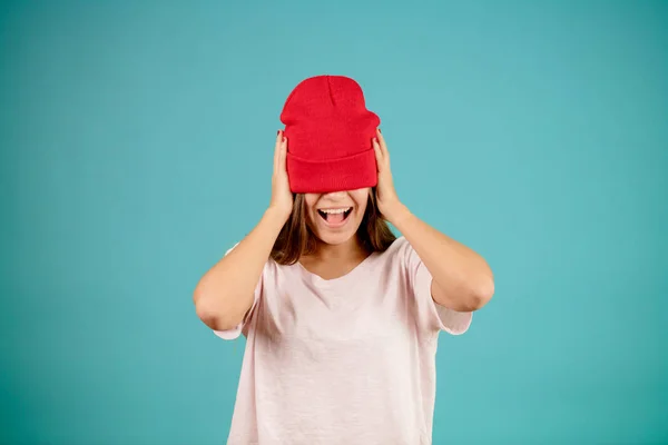 Leende ung trevlig kvinna försöker på toobig röd cap — Stockfoto