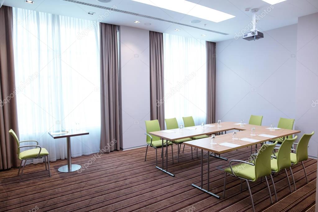 negotiation room with green chairs and wooden tables