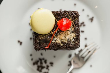 çikolata ve fındık sprinkles ve kiraz ve tereyağı krema ile pişmiş kek.