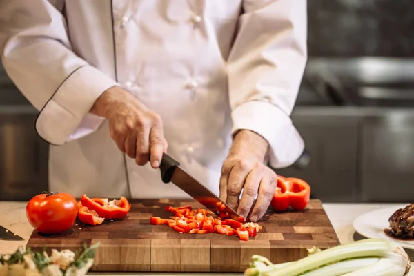 Közelkép Fotó vágott mans kezében daraboltak fel piros paprika — Stock Fotó