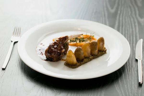 Prato de carne com batatas cozidas na mesa branca — Fotografia de Stock