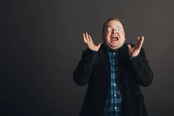 Hombre celebrando grasa hacer loco amante face.crazy bitcoin con moneda de oro por los ojos —  Fotos de Stock