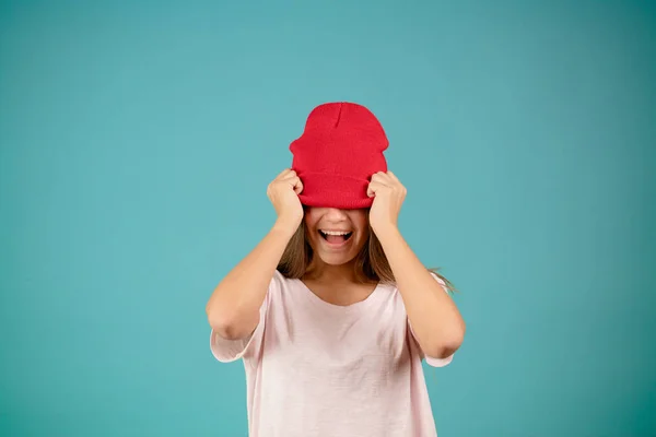 Joven divertida hembra escondida bajo su gorra de punto rojo — Foto de Stock