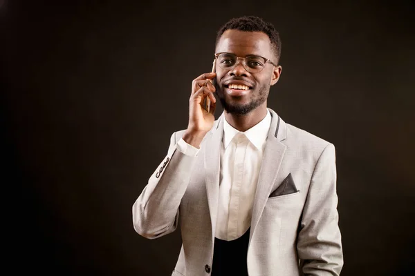 El jefe afro hace una llamada y arregla una reunión por teléfono. concertar una cita — Foto de Stock