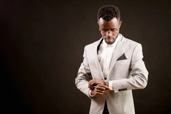 Retrato del hombre de negocios afro guapo mirando el reloj en su brazo — Foto de Stock