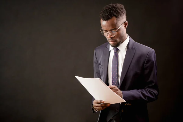 Nero ragazzo in occhiali e abbigliamento formale scrittura su carta in ufficio — Foto Stock